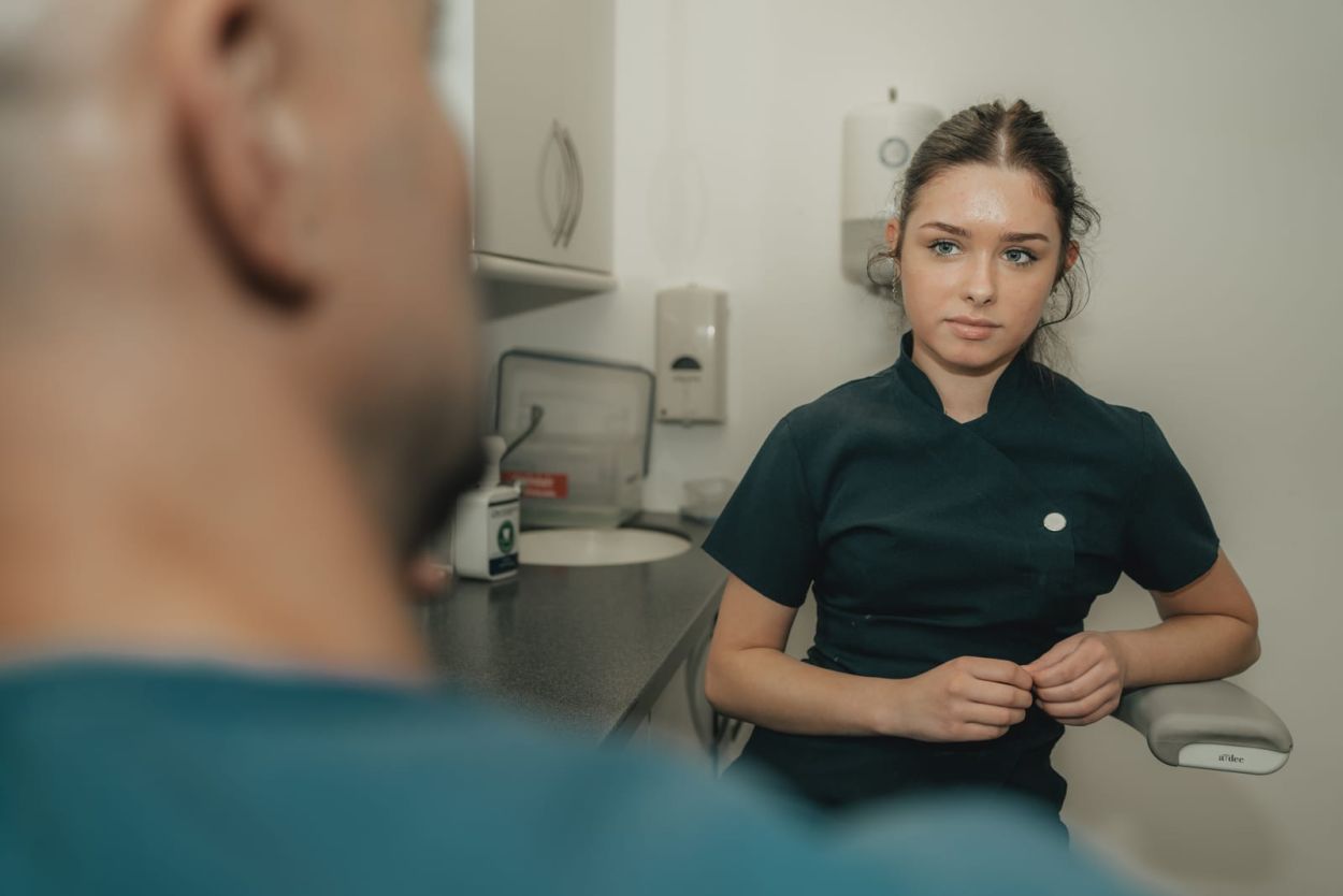 Dentist showing a patient a dental crown model at Glendair Dental